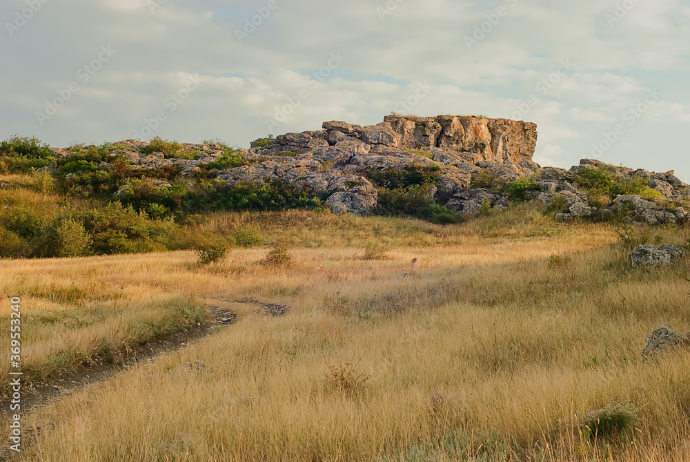 The rocks in the Azov steppe at the dawn under the blue sky in Ukraine