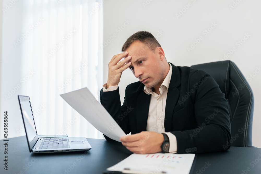 The thoughtful man at work reads from a piece of paper. The thoughtful man at work reads from a piece of paper.