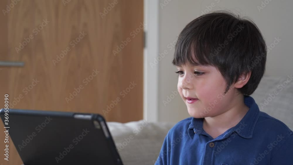 School Kid using tablet taking with his class friends,Child boy studying online on touch pad, new normal lifestyle with learning online, Distance education School Kid using tablet taking with his class friends,Child boy studying online on touch pad, new normal lifestyle with learning online, Distance education