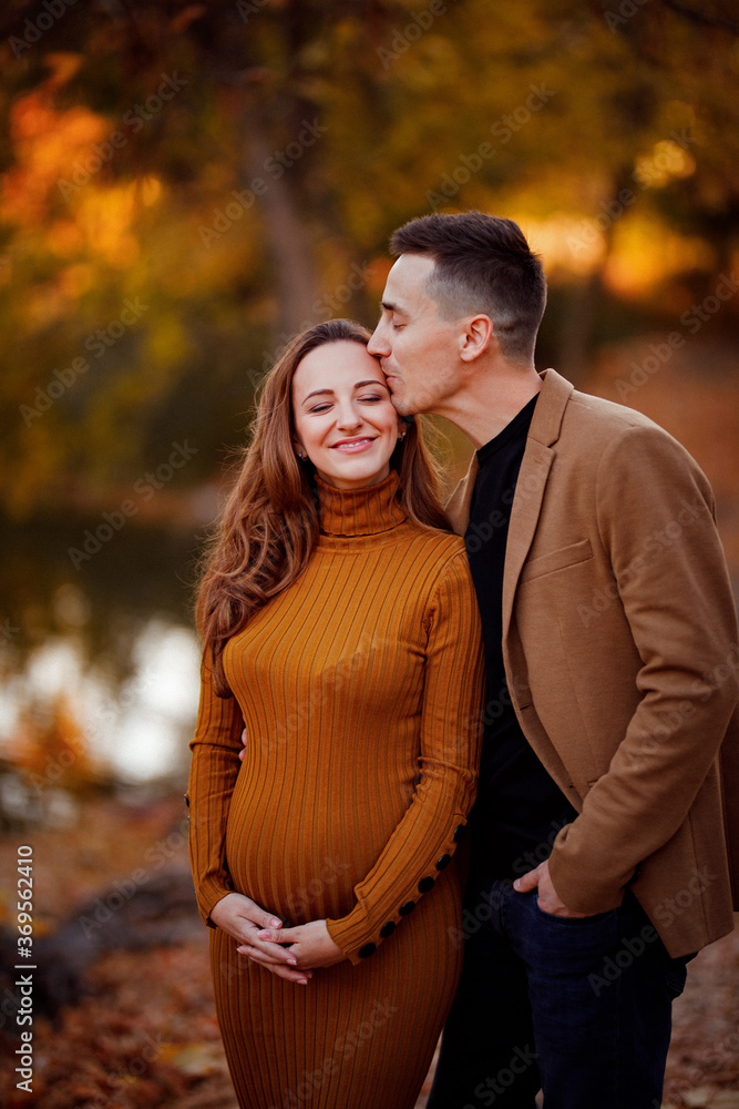 pregnant with husband in autumn Park by river. pregnant with husband in autumn Park by river.