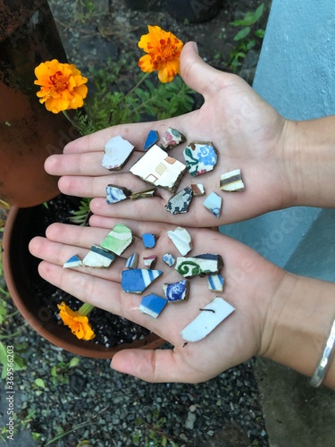 hands with broken pottery