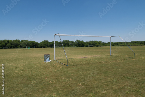 a large soccer field with 9 goals and one trash can