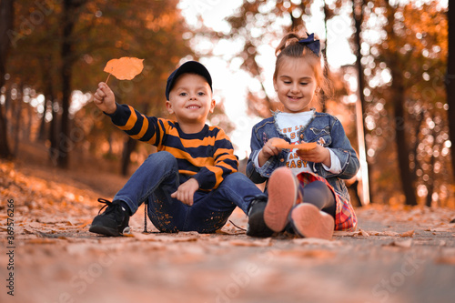 Cute boy and girl in autumn park.