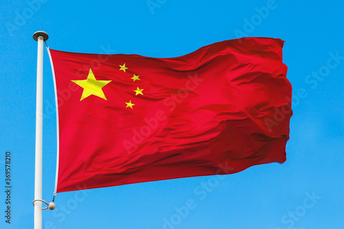 The flag of China close up. Five-starred Red Flag is against blue sky.