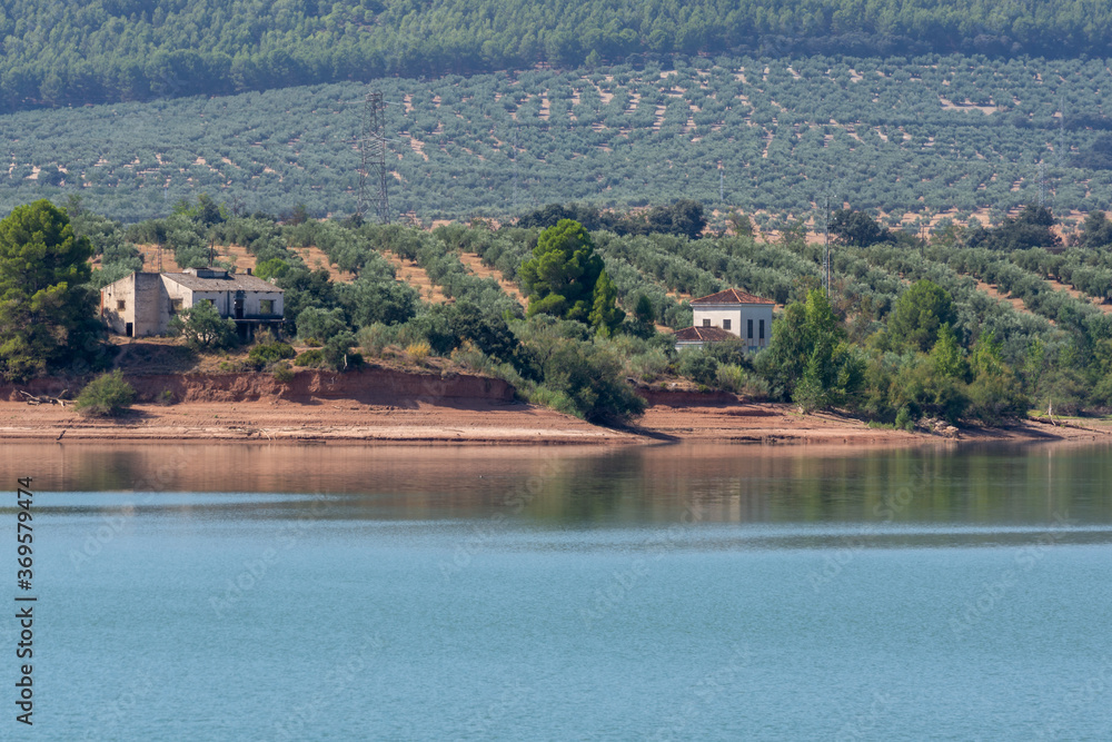 Andalusian landscape with lake and hills planted with olive trees