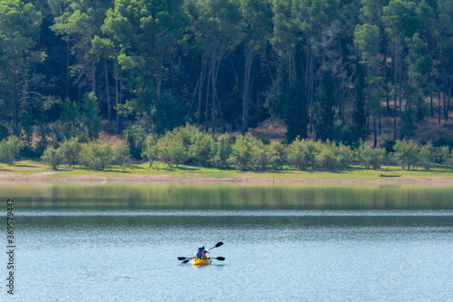 Two women kayaking on a lake one summer morning in Andalusia