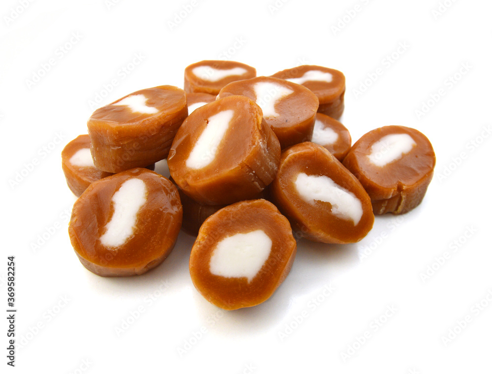 Delicious caramel candies on a white background. Delicious caramel candies on a white background.