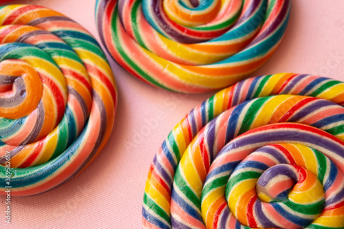 Colorful swirl lollipops arranged on a pink background.