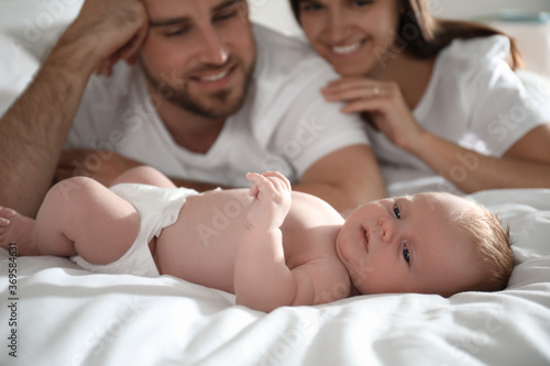 Happy couple with their newborn baby on bed, closeup