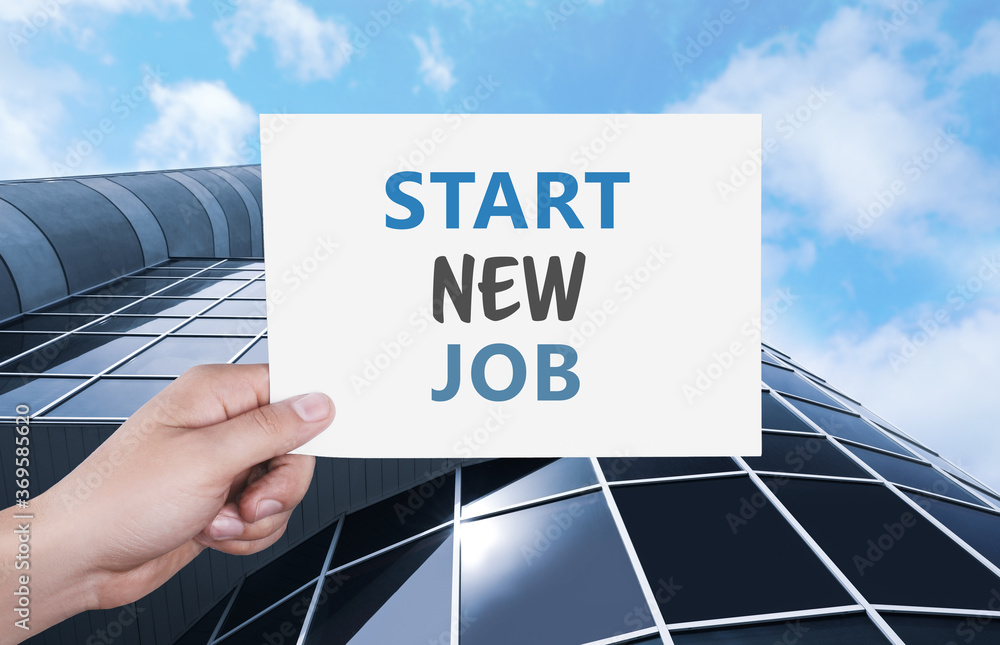 Change your life. Man holding card with text Start New Job against modern building, closeup Change your life. Man holding card with text Start New Job against modern building, closeup