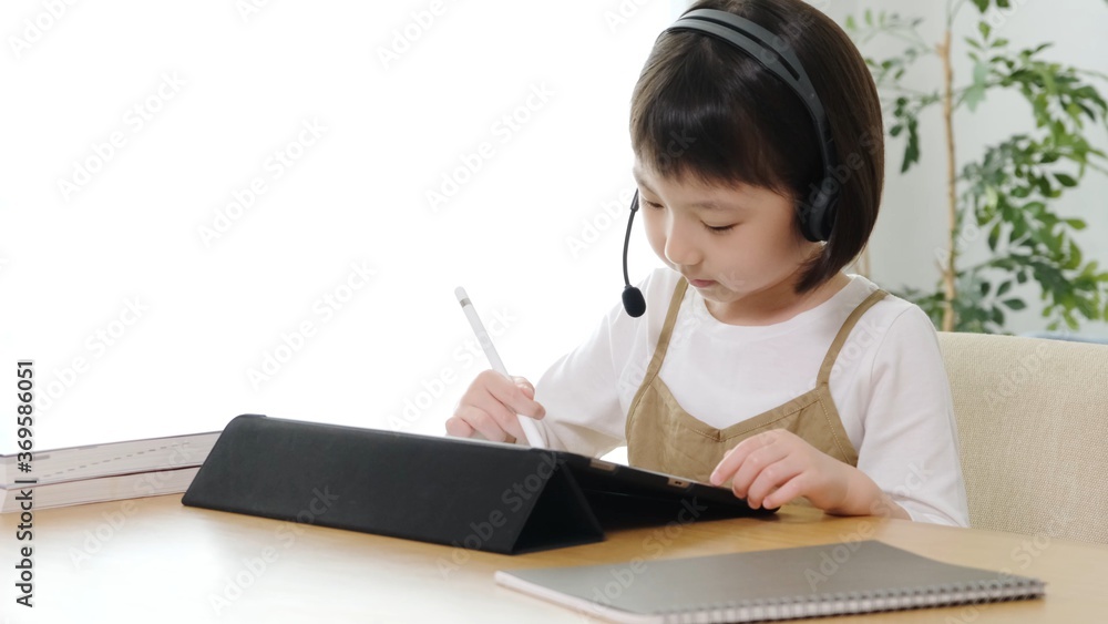 タブレットを使って自宅で勉強する女の子 タブレットを使って自宅で勉強する女の子