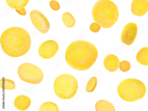 Yellow carrot slices falling on white background