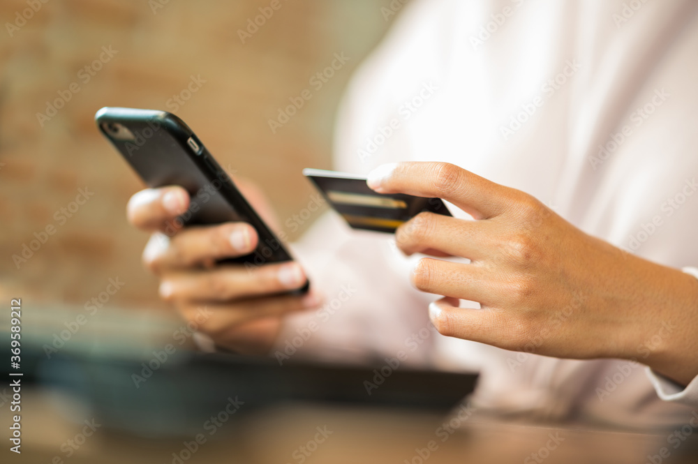 Woman wearing surgical mask in cafe shopping online with Mobile Phone - obrazy, fototapety, plakaty 