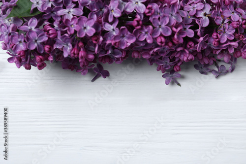 Beautiful lilac blossom on white wooden background, flat lay. Space for text © New Africa