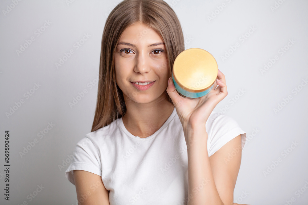 Young pretty woman holding moisturizing cosmetic cream Young pretty woman holding moisturizing cosmetic cream