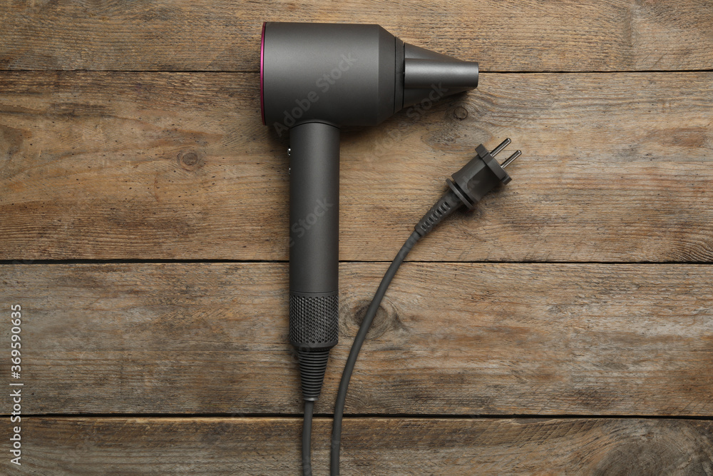 Hair dryer on wooden table, top view. Professional hairdresser tool Hair dryer on wooden table, top view. Professional hairdresser tool