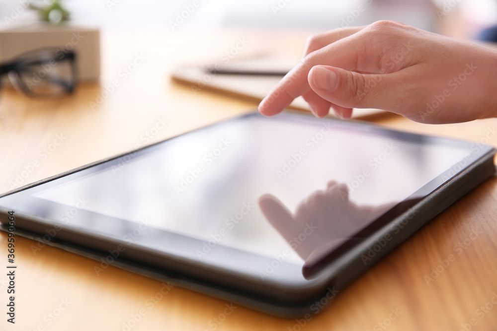 Woman working with modern tablet at wooden table, closeup Woman working with modern tablet at wooden table, closeup