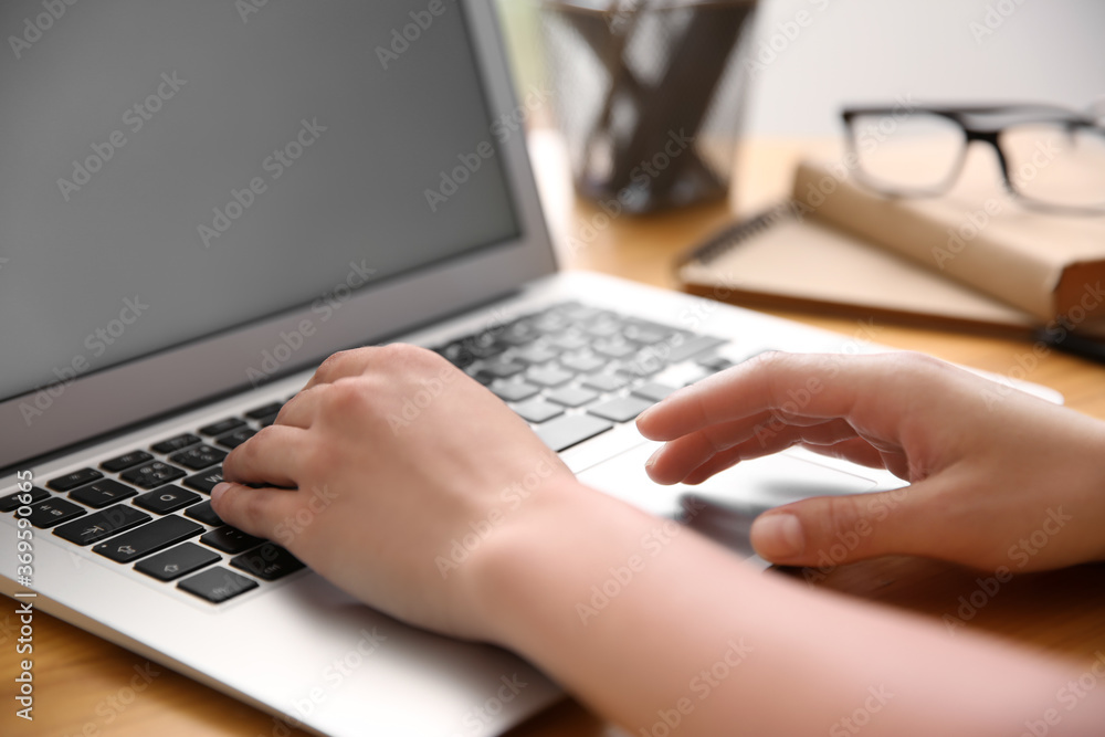 Woman working with modern laptop at wooden table, closeup Woman working with modern laptop at wooden table, closeup