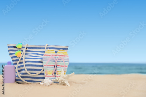 Bag and beach objects on sand near sea, space for text