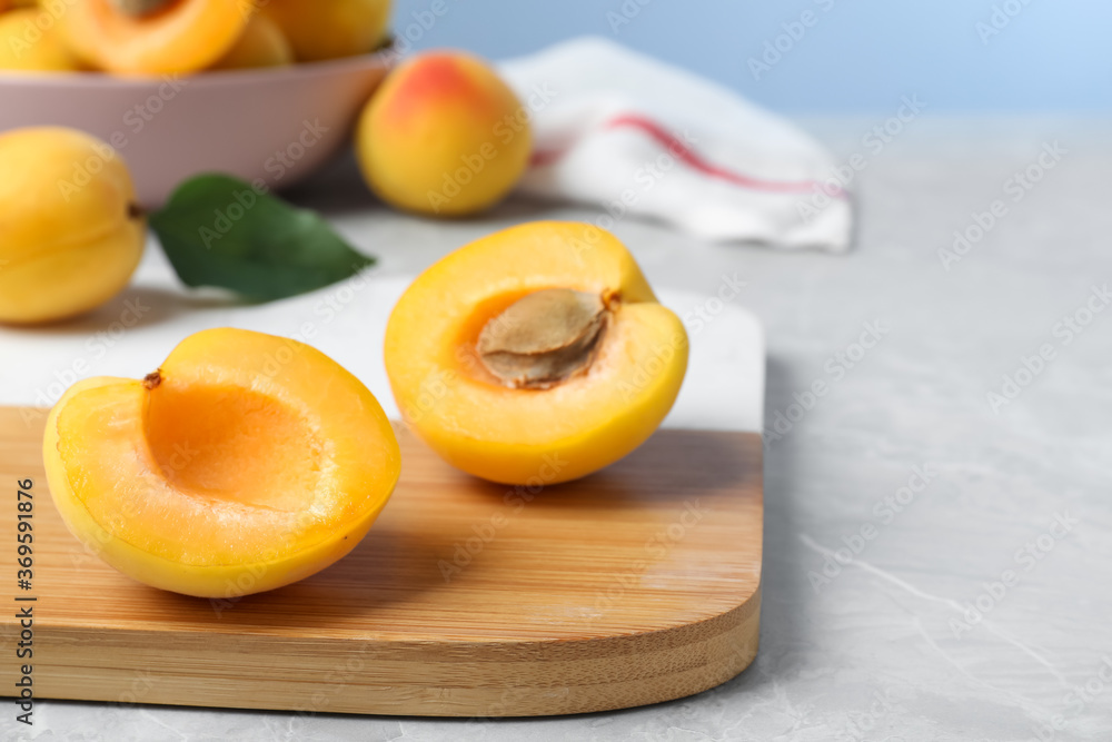 Halves of delicious fresh ripe apricot on grey table. Space for text