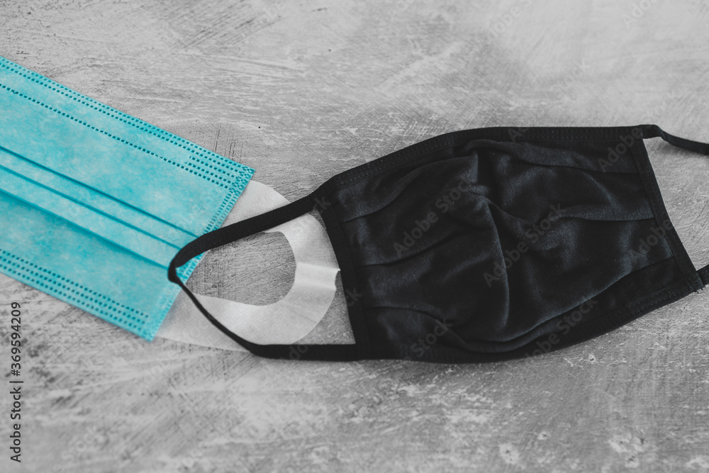Naklejka premium covid-19 prevention concept, different face masks including surgical mask, fabric and construction ones on concrete surface