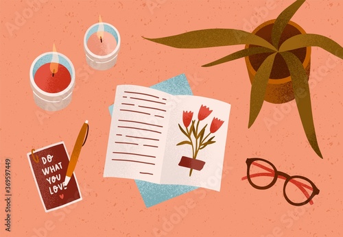 Notepad or diary with dry beautiful flower and writing text surrounded by cosiness things on desk vector flat illustration. Top view of cozy workplace organization with candles, accessories and plant