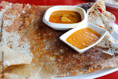 Rava dosa or Ravvattu or Rave Dose, is an Indian crepe of South India serve with curry and chilli sauce 