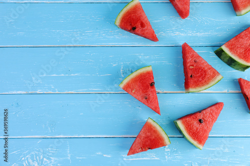 Slices watermelon flat lay composition on the blue color wooden background. Watermelon is the fruit of summer for healthy.