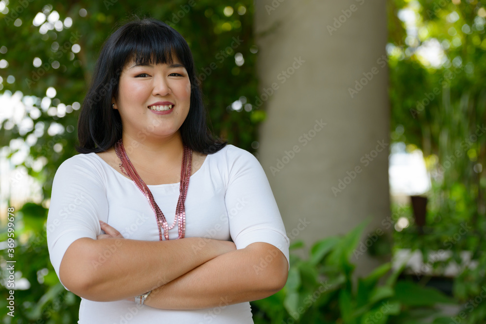Happy young beautiful overweight Asian woman at the park Happy young beautiful overweight Asian woman at the park