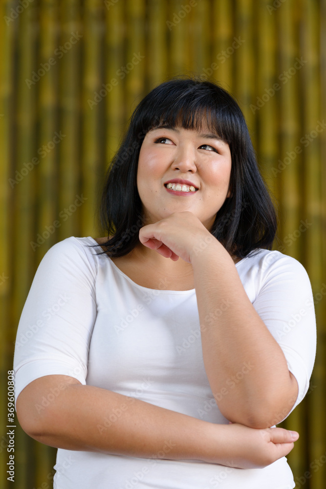 Happy young beautiful overweight Asian woman outdoors Happy young beautiful overweight Asian woman outdoors