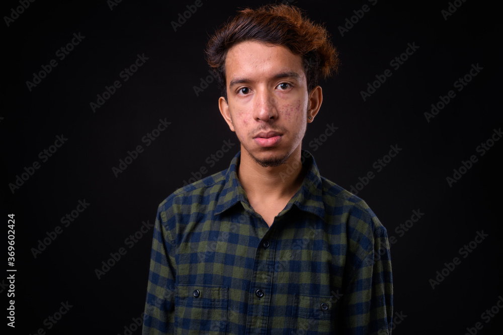 Portrait of young Asian hipster man with curly hair