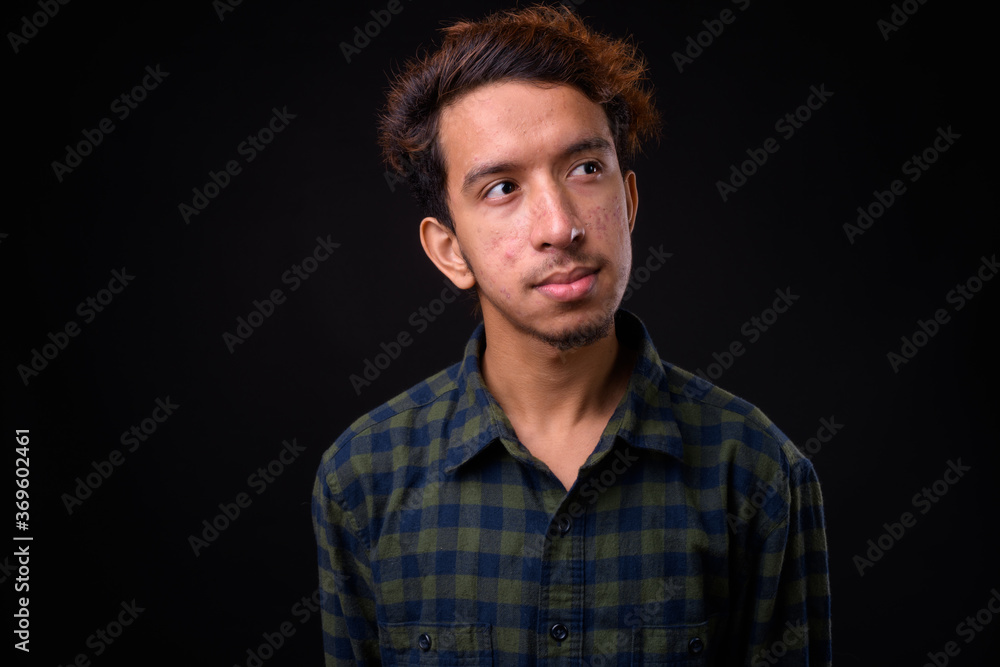 Portrait of young Asian hipster man with curly hair