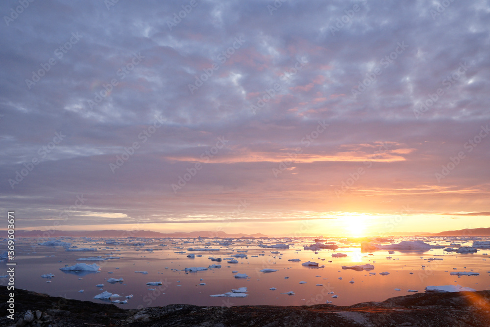 Fototapeta premium Midnight Sun and icebergs in Disko Bay, Ilulissat, West Greenland