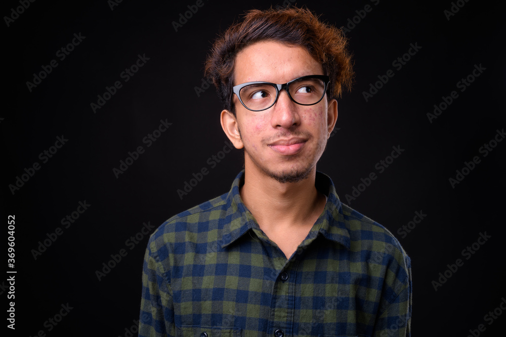 Obraz premium Portrait of young Asian hipster man with curly hair