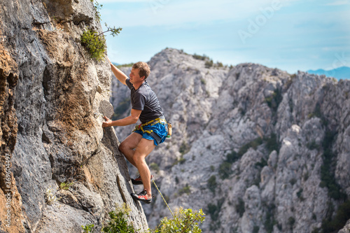 Rock climber on the background of mountains and sea.