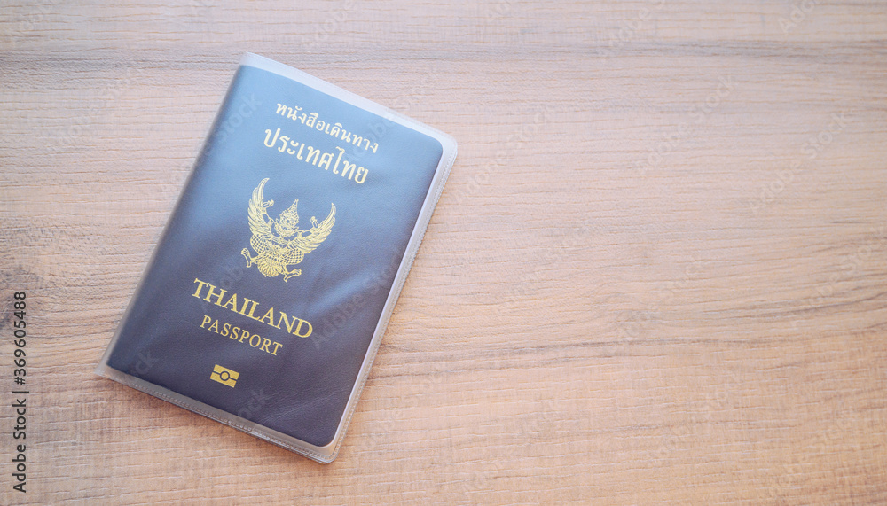 High angle view of Thailand passport on wooden table with empty copyspace. High angle view of Thailand passport on wooden table with empty copyspace.