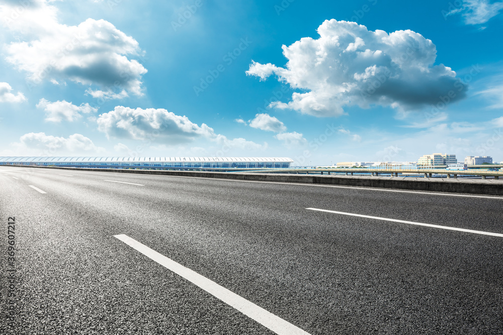 Fototapeta premium Asphalt road ground and airport buildings with blue sky in Shanghai.