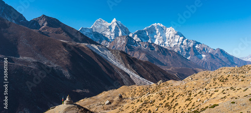 Kangtega and Thamserku mountain peak view from Dingboche village in Everest base camp trekking route. Himalaya mountains range in Nepal. Panoramic banner portion.