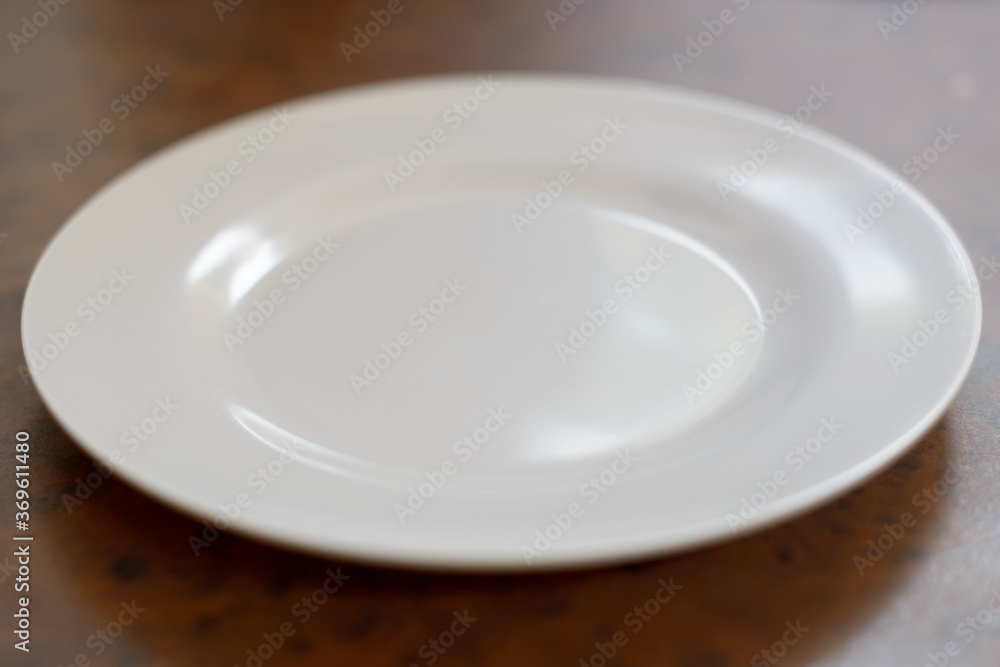 Portrait of white plate on wooden table Portrait of white plate on wooden table