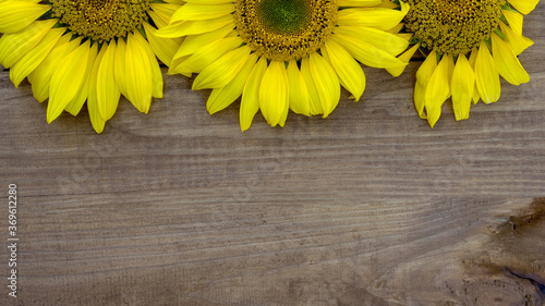 Yellow sunflowers on wooden background, close up, copy space.