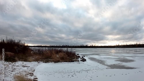 Panoramic view of Lake Stewart with the sun passing through the clouds showing animal tracks on the ice