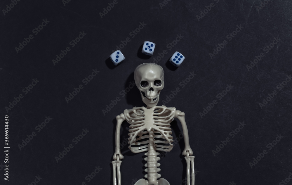 Skeleton and dice on black background. Gambling addiction. Top view Skeleton and dice on black background. Gambling addiction. Top view