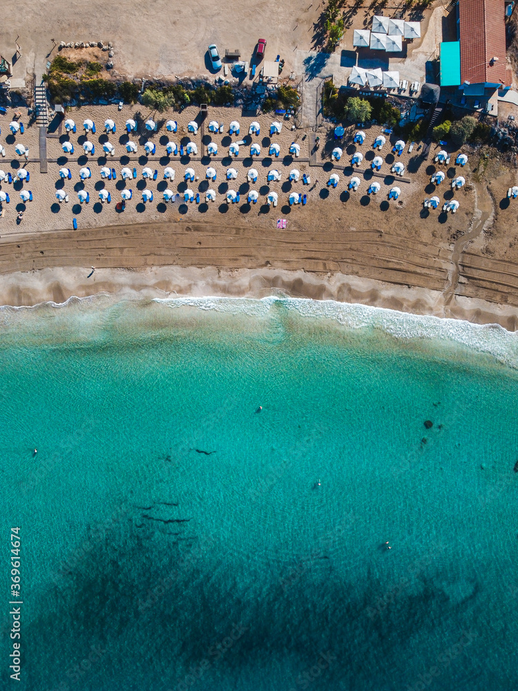 Aerial view over Coral Bay - the most beautiful beach in Paphos area, Cyprus. Crystal clean blue and turquoise  waters and soft white sand makes it a perfect summer vacation destination.