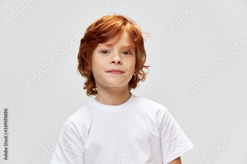 Cute redhead boy in white t-shirt cropped view of freckles on his face 