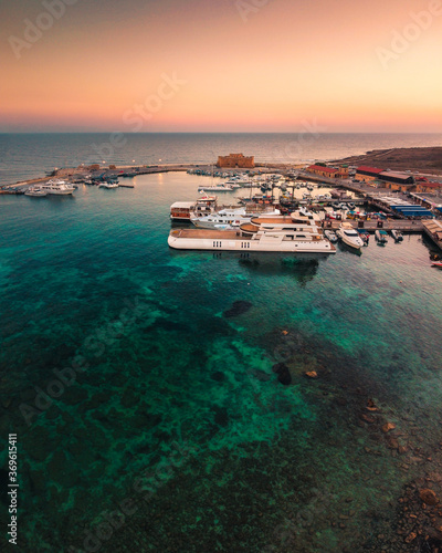 Beautiful aerial sunset shot of Paphos Castle and Paphos Harbor in Cyprus. Crystal clear water, fishing boats, luxury yachts - amazing travel destination for all year vacation.  © Evgeni