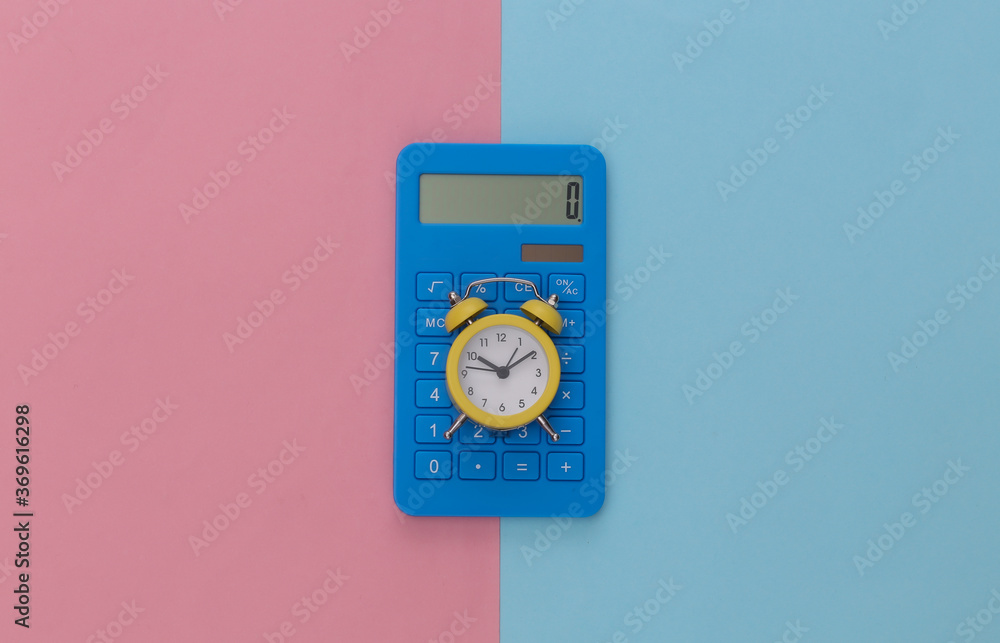 Calculator and alarm clock on pink blue pastel background. Top view. Flat lay Calculator and alarm clock on pink blue pastel background. Top view. Flat lay