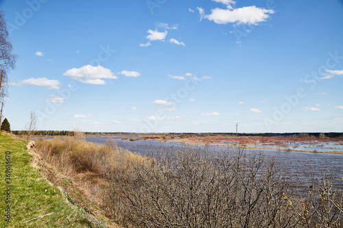 High water on a river or on a lake in sunny spring day