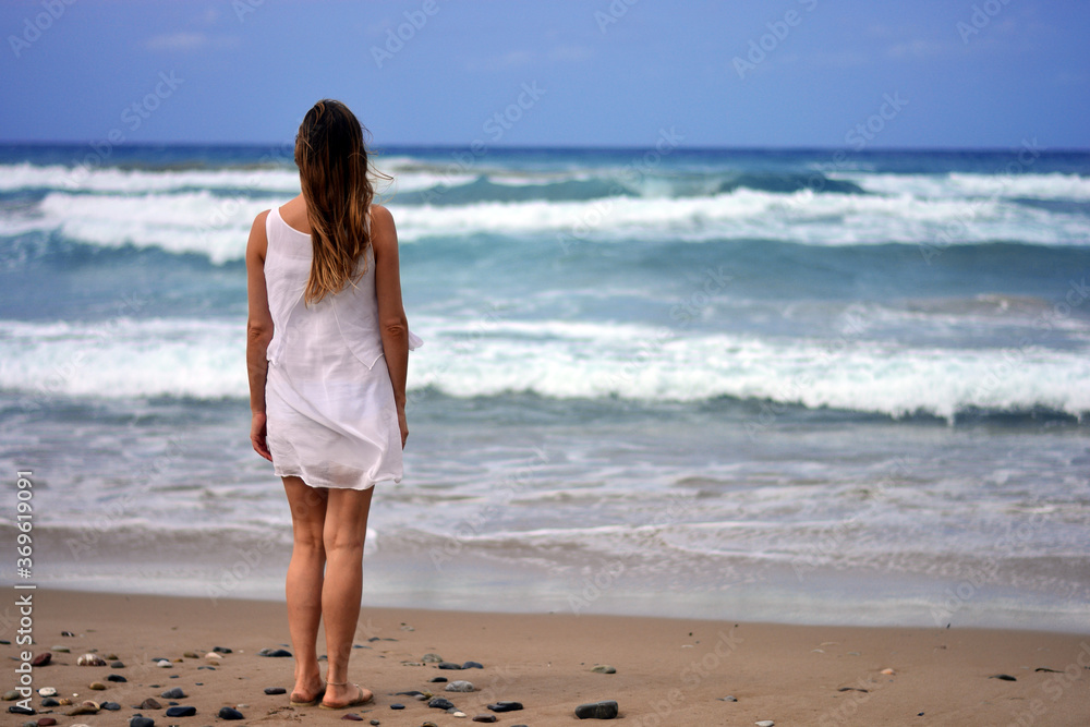 the woman observes the waves of the sea the woman observes the waves of the sea