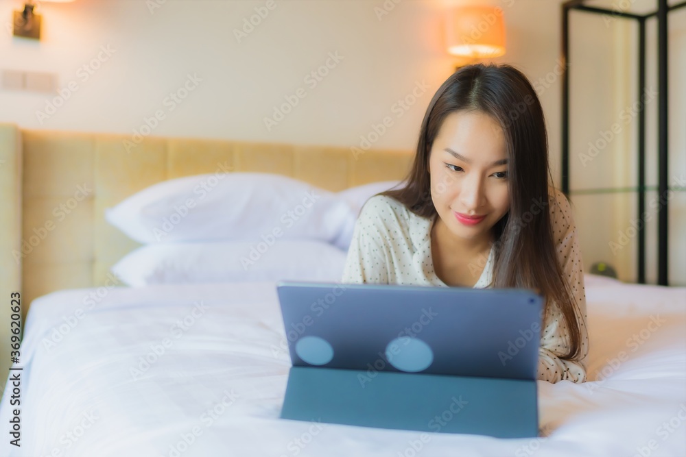 Portrait beautiful young asian woman use tablet with credit card on bed Portrait beautiful young asian woman use tablet with credit card on bed