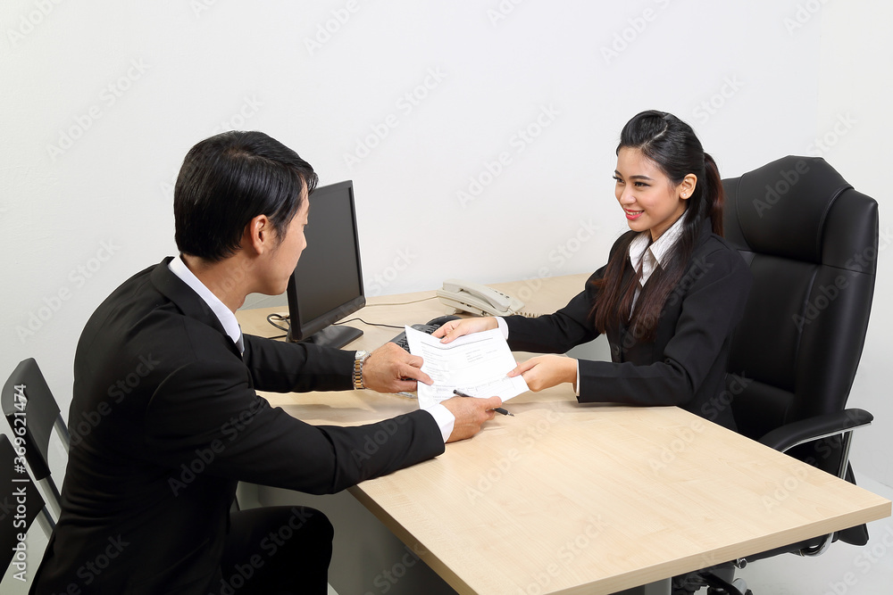 Young Asian male female wearing suit sitting at office desk thinking meeting disucsing sign document agreement Young Asian male female wearing suit sitting at office desk thinking meeting disucsing sign document agreement